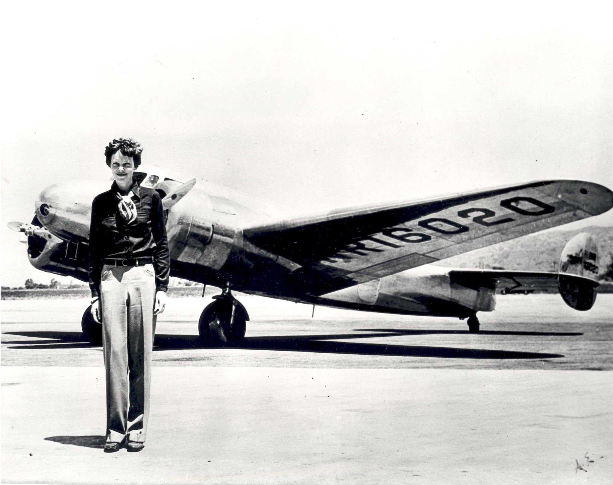 Earhart poses in front of the Lockheed Electra in which she disappeared in July 1937.