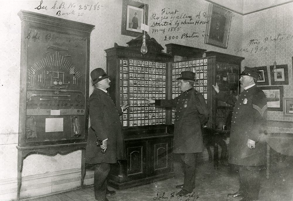 Chief John F. Farley, center, examines the Denver Police Department’s “rogues’ gallery,” containing around 2,000 mugshots, photo dated January 1, 1900. Howe claimed to have started the rogues’ gallery in May 1885. 