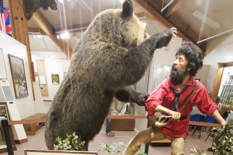 A diorama of Hugh Glass exiting, pursued by a bear.