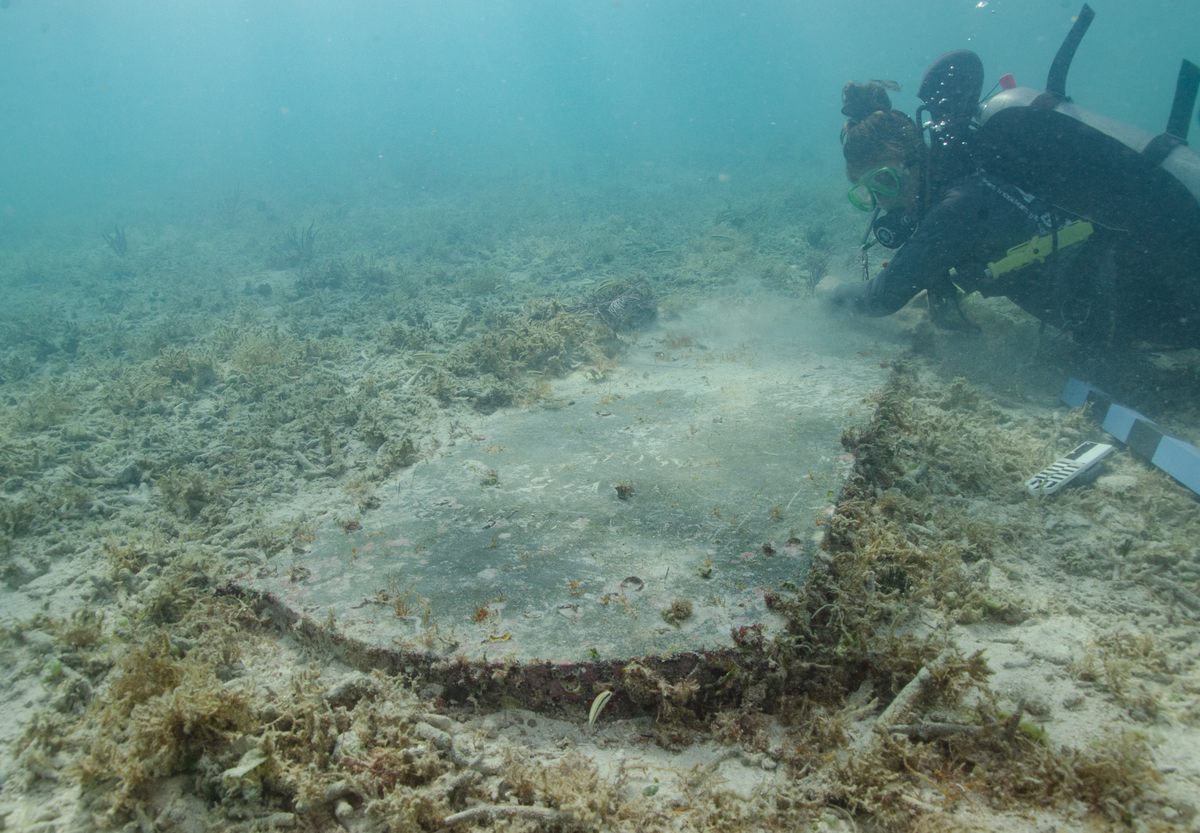 Mahasiswa pascasarjana Universitas Miami Devon Fogarty memeriksa nisan John Greer, yang meninggal saat bekerja di Fort Jefferson pada 5 November 1861. Kuburan sekarang benar -benar di bawah air.