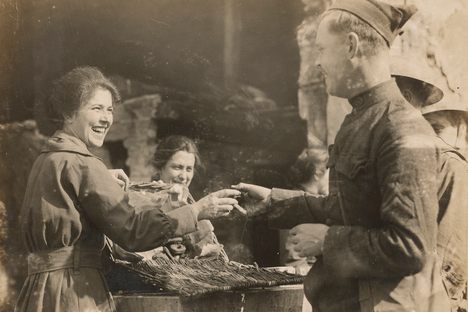 A member of the Salvation Army hands a doughnut to a soldier in Ansonsville, France, April 1918.