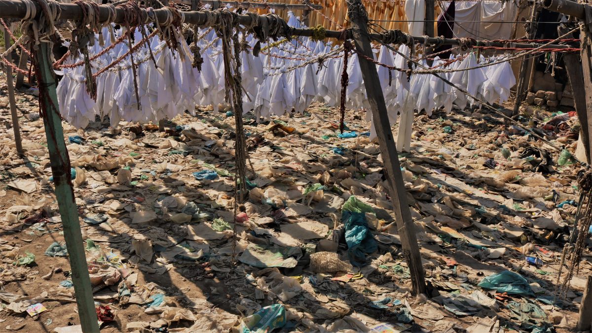 Clean linens hang over an expanse of trash at Karachi's dhobi ghat.