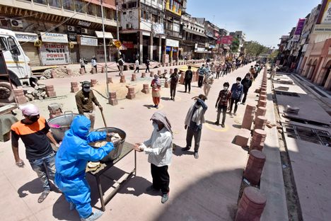 Indians collect meals distributed on day 19 of the 21-day nationwide lockdown in New Delhi, India. 