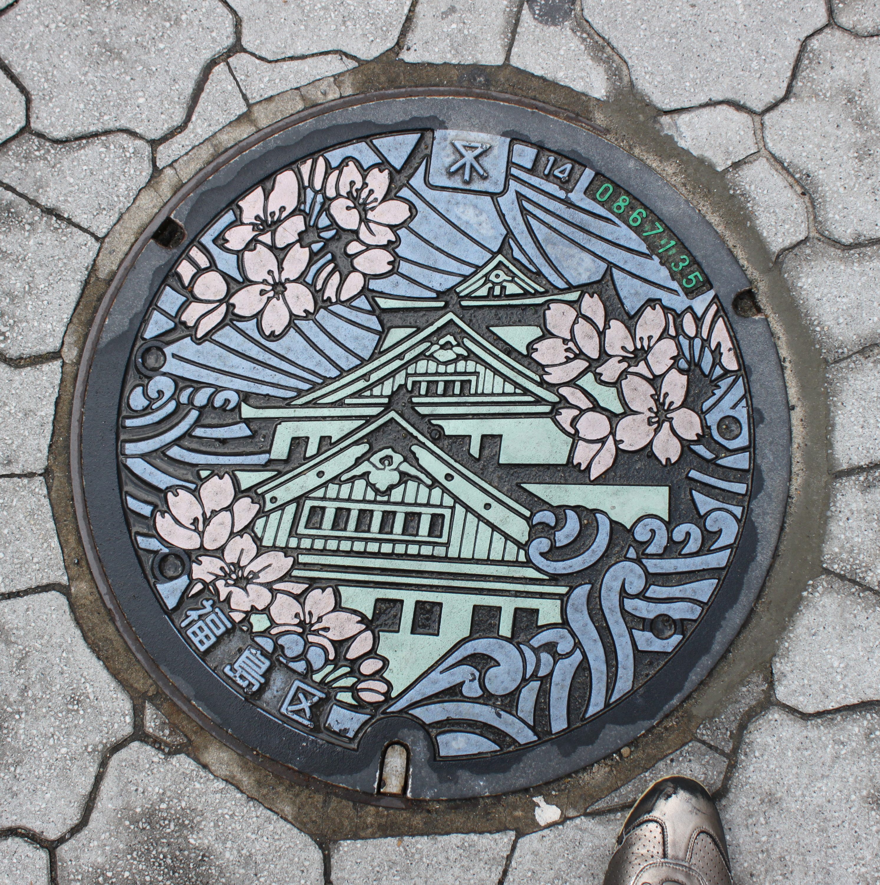 A manhole cover depicting Osaka Castle.