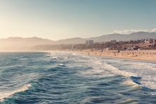 View of Santa Monica Beach and Los Angeles in afternoon sun. Aerial view from above the pacific ocean water.