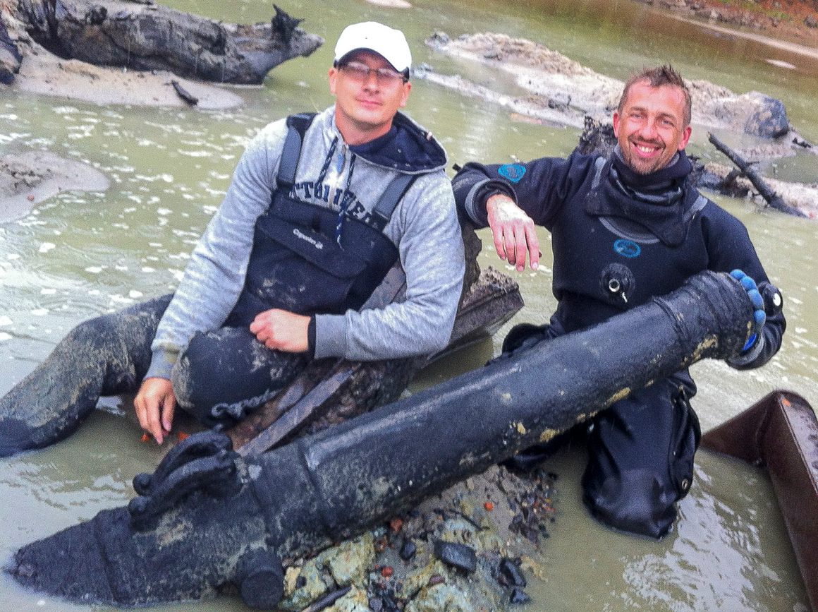 Hubert Kowalski (L) and Marcin Jamkowski with the 17th century cannon