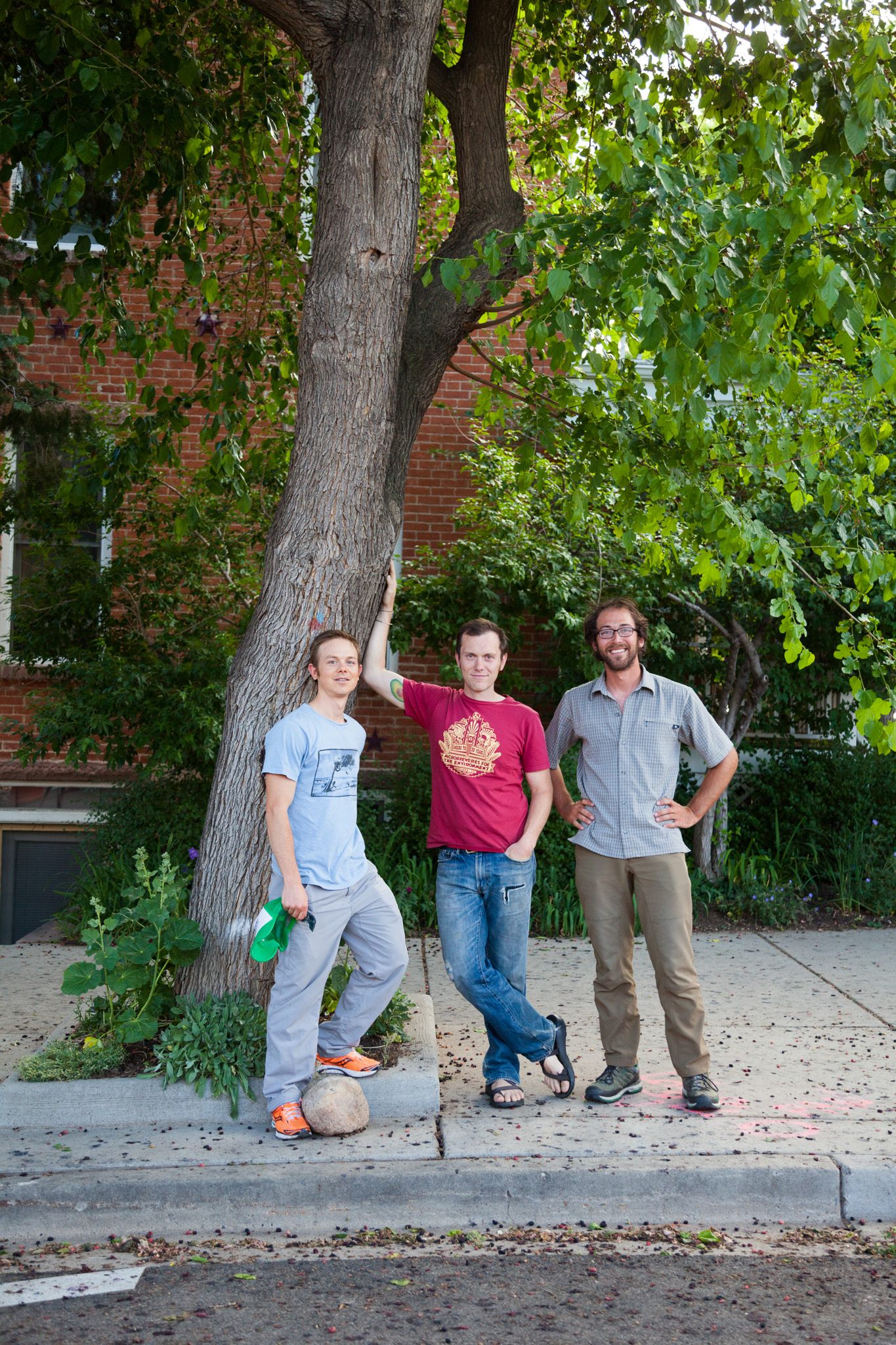 Jeff Wanner (left-right), Caleb Phillips, and Ethan Welty stand below a large mulberry tree on the street in Boulder.
