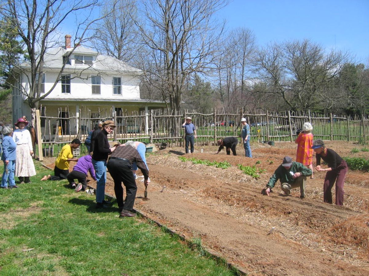 Visitors to Button Farm use 19th-century tools to perform agricultural tasks.