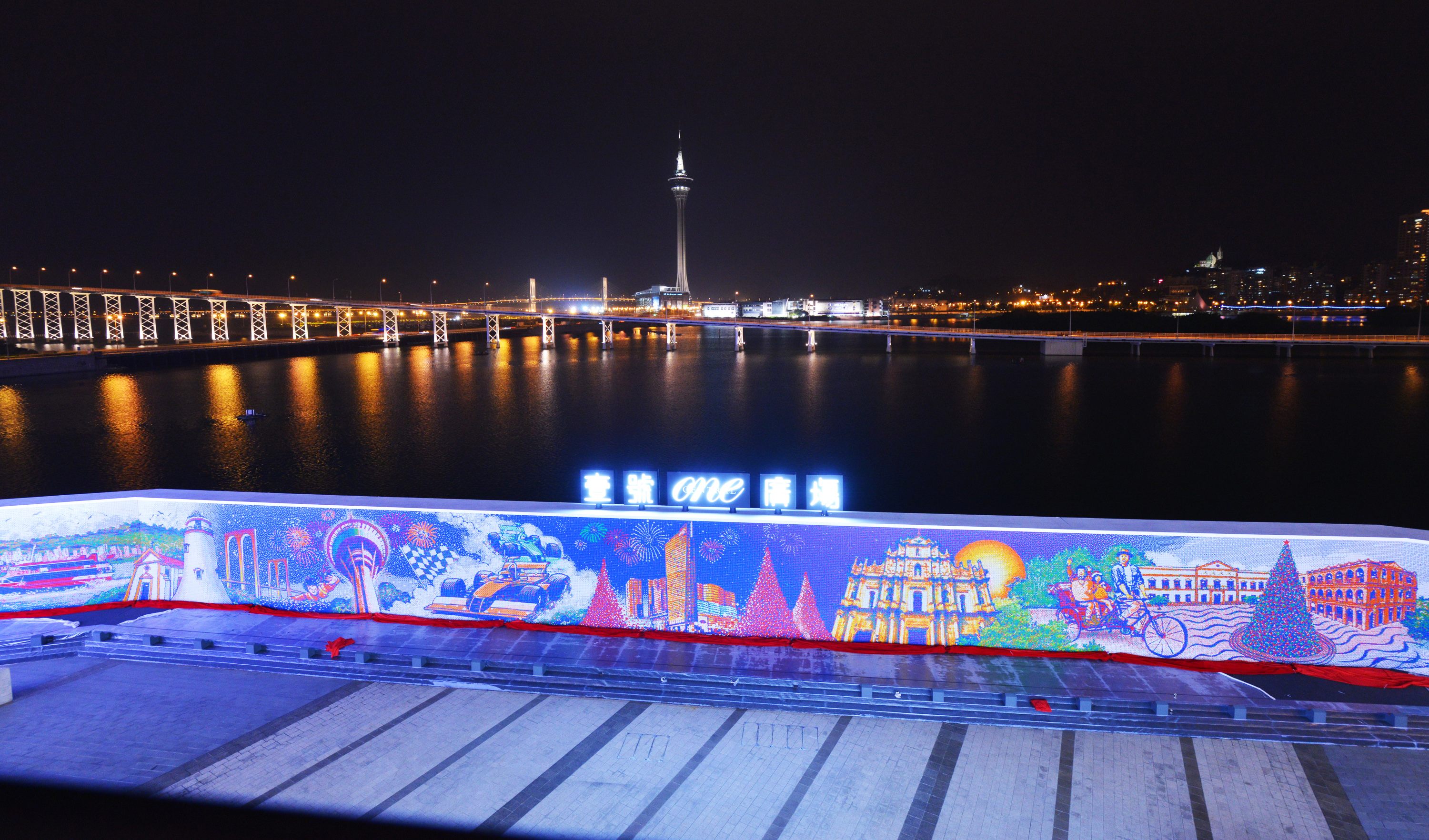 The Macau mural of the night skyline, glowing by the city's waterfront. 
