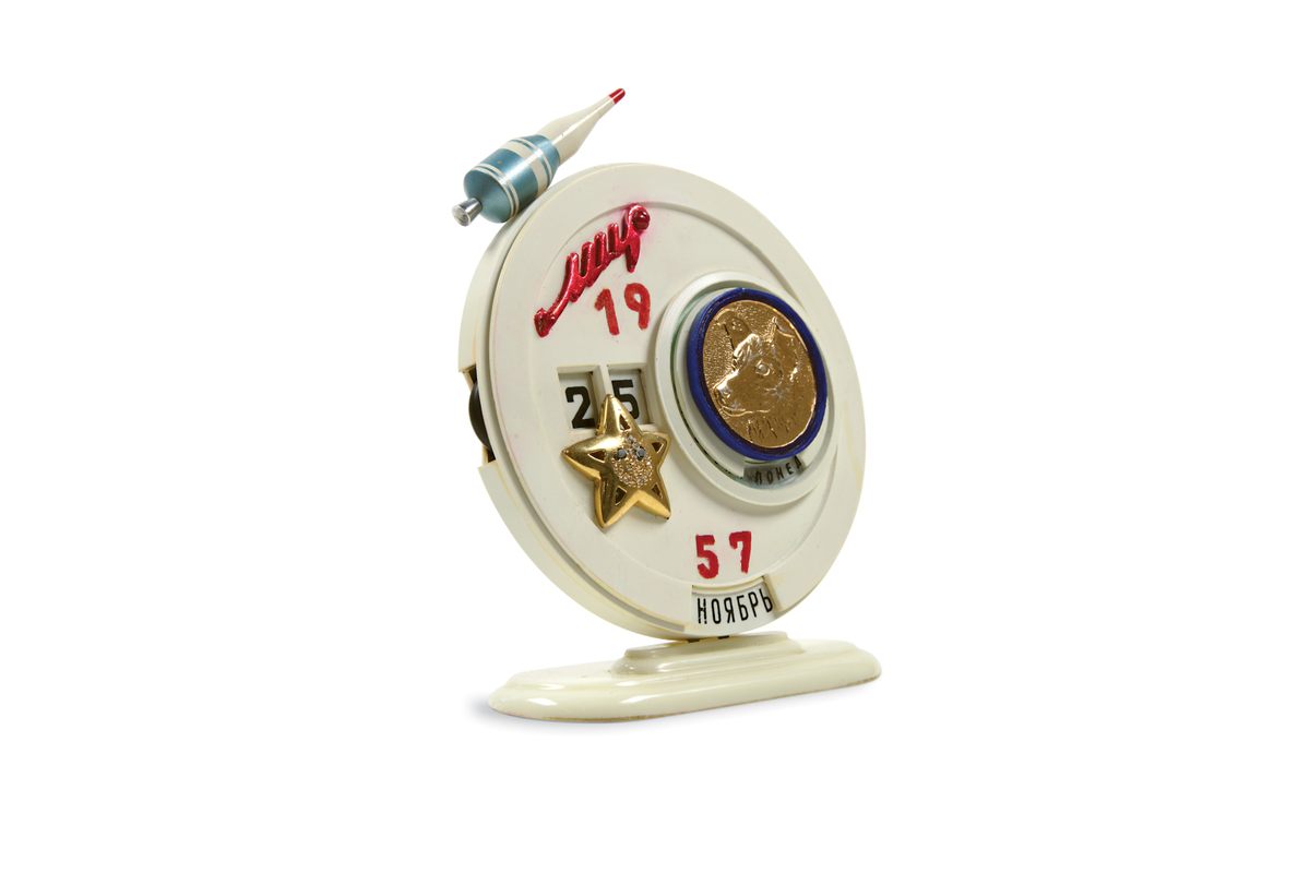 This 1957 rotary-dial desk calendar features an embossed Laika and a model space capsule.
