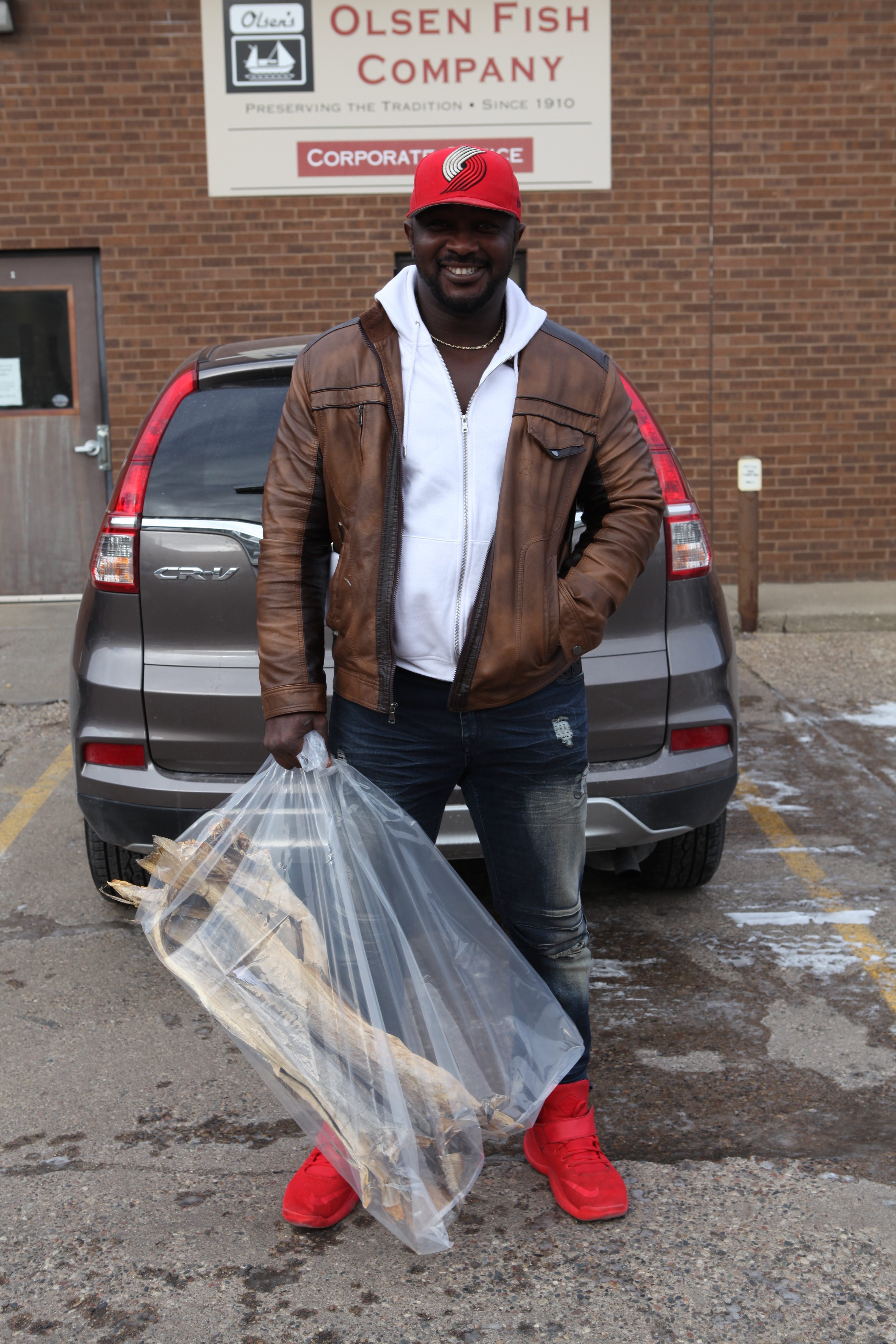 Customer Jeremiah Nnaji buys a bag of stockfish from Olsen Fish Company.