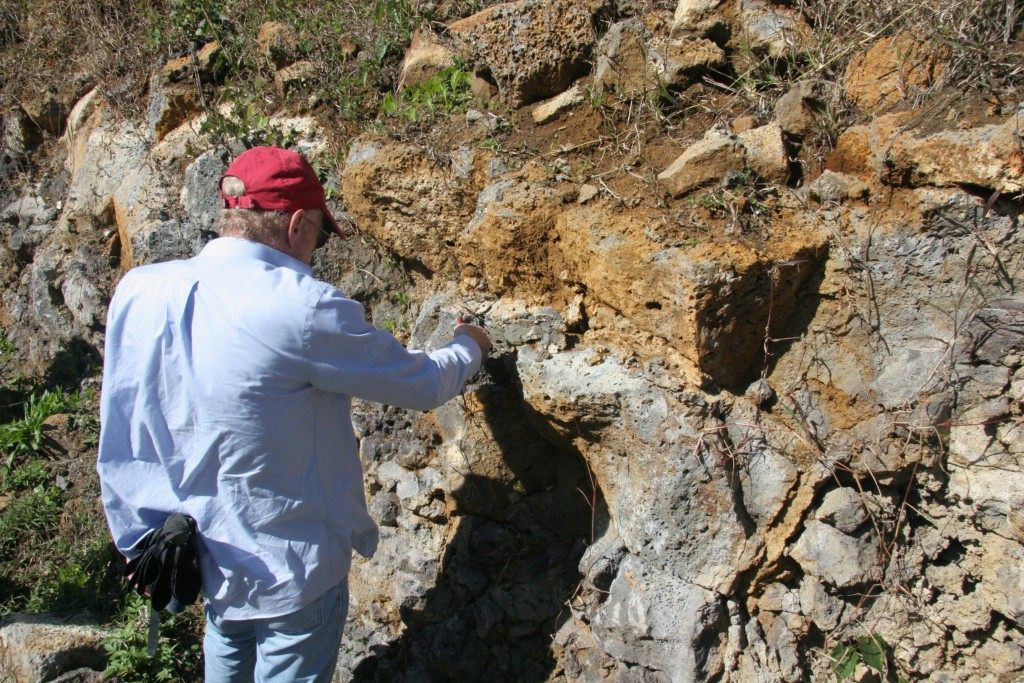 The report's lead author examining volcanic rock.
