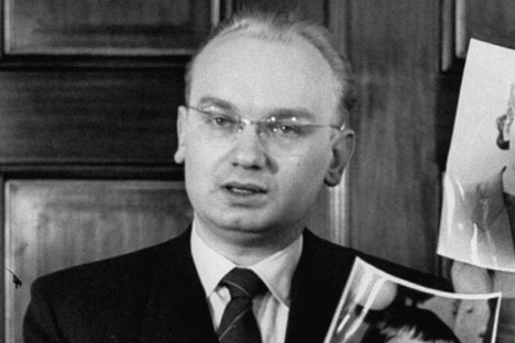 KGB agent Nikolai Khokhlov, who defected from Russia in 1954, holding up pictures of his wife and son.