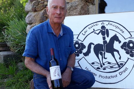 Hervé Garnier poses with a bottle of wine from Beaumont.