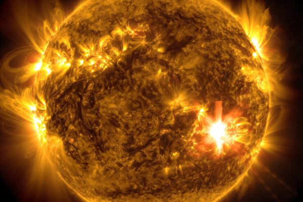A powerful X3.9 solar flare, visible at lower right, erupts on May 10 in an image captured by NASA’s Solar Dynamics Observatory.