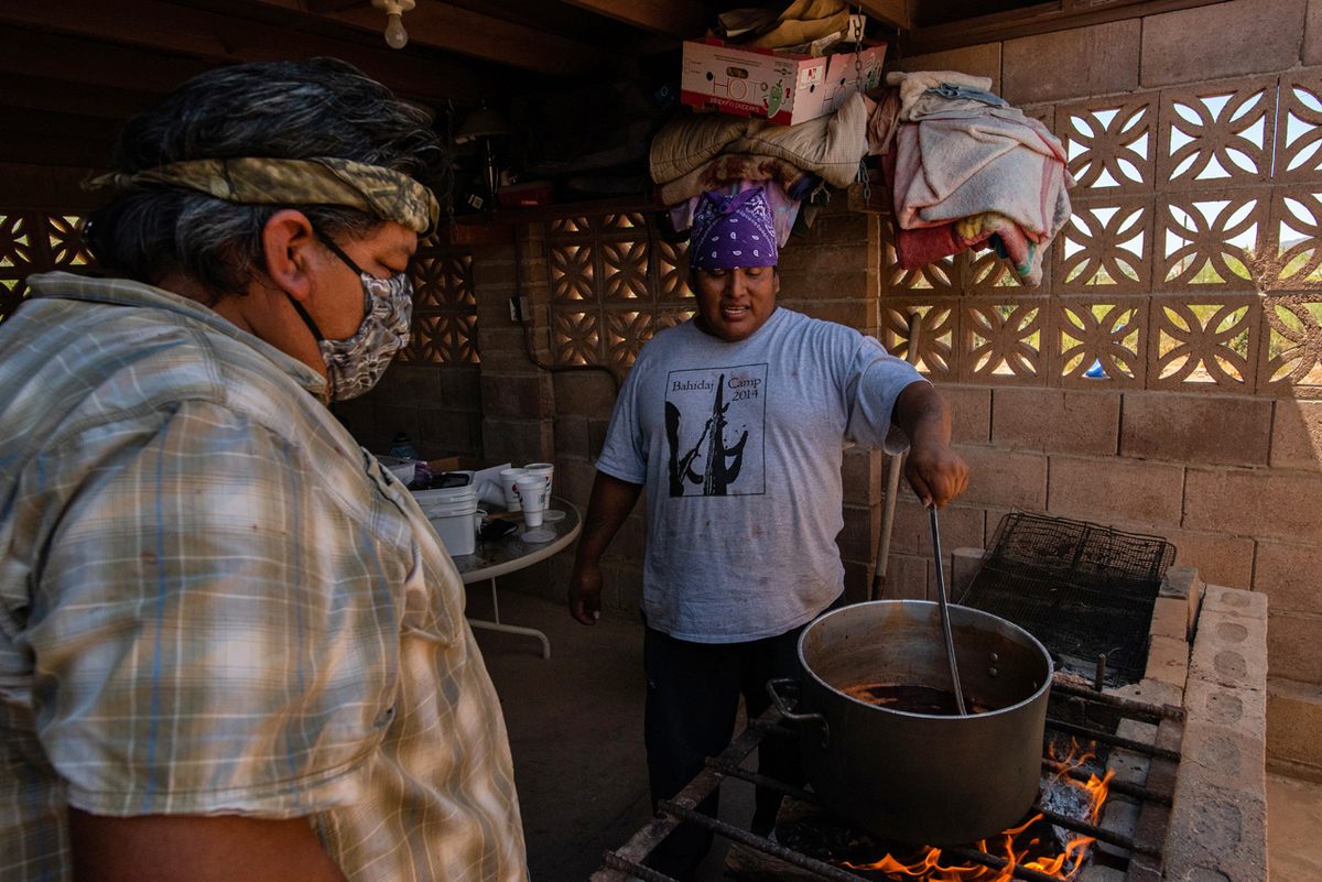 Jesse Pablo cooks saguaro fruit pulp into a syrup under the watchful eye of Noland Johnson.