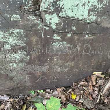 Centennial Rock with the carvings "E Suydam 1876 M Danbury Centennial Year." Followed by the mysterious cypher. Unfortunately, weathering and possible vandalism has made much of the carving illegible. Early images of the carving in a better state of preservation can be viewed here: https://weirdnj.com/stories/cryptic-carvings-along-lawrence-brook/
