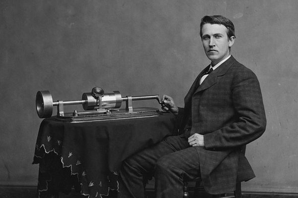 Edison poses by his phonograph in a photograph from 1878.