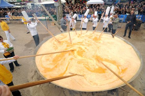 Members of the Giant Omelette Brotherhood stir more than 15,000 eggs on March 28, 2016, on the main square of Bessieres, France.