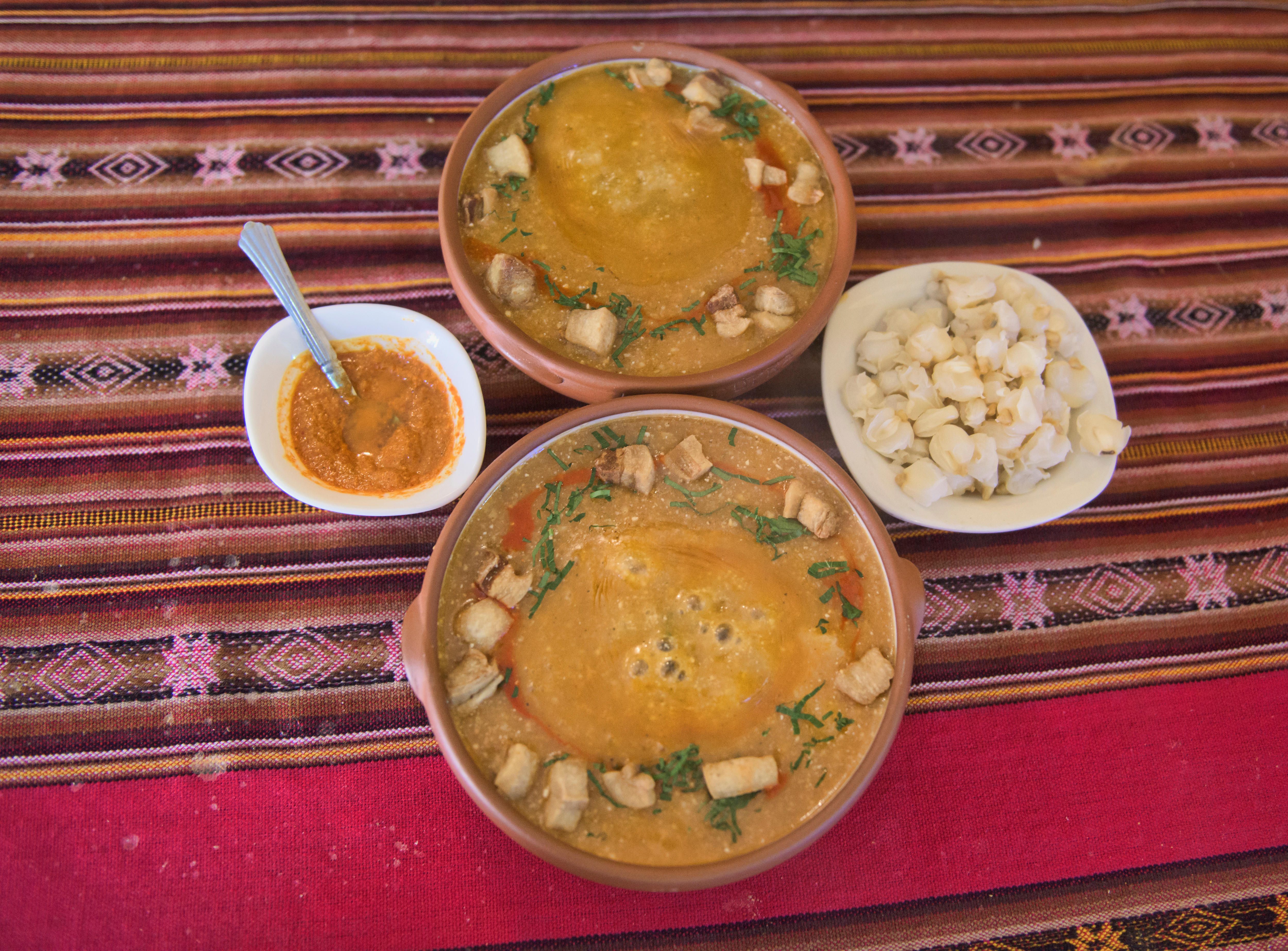 Two bowls of k'alapurka sizzle with the heat of volcanic rocks.
