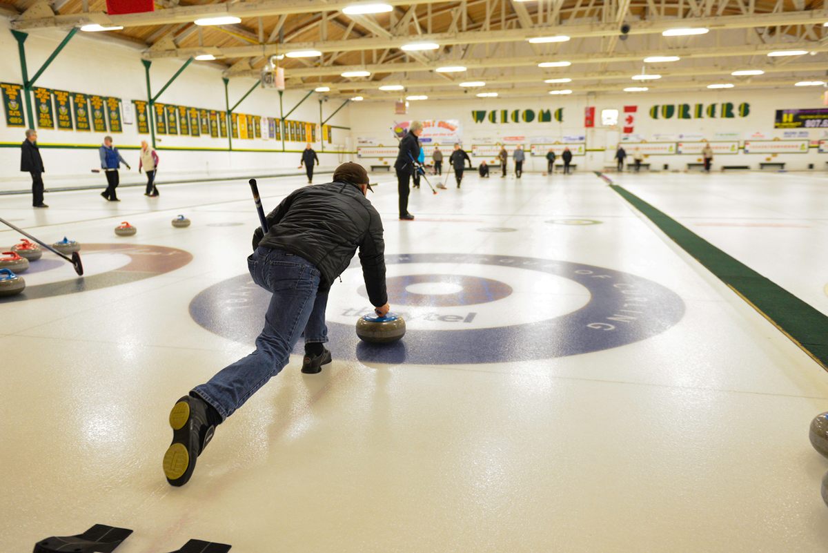 Inside Port Arthur Curling Club, players slide stones across the ice.