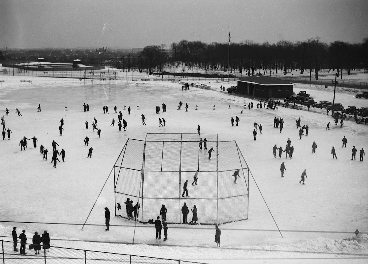 Flooded ballpark with skaters, Central Park, 1938.