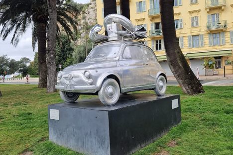 The over-stuffed Fiat 500 has a piled-high roof rack and stickers in the rear windows.