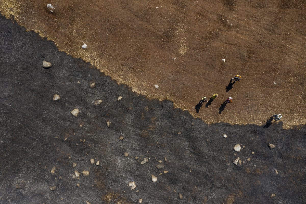 The crew assesses the perimeter burn, which will prevent the fire from jumping from the center of the field to other areas.