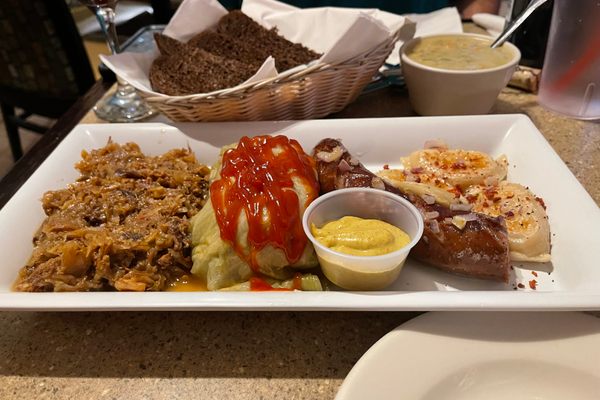 A sample platter of meats, with plenty of mustard.