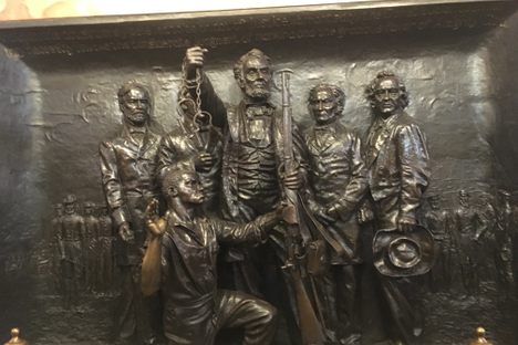 Lincoln holding a rifle, freeing the slaves