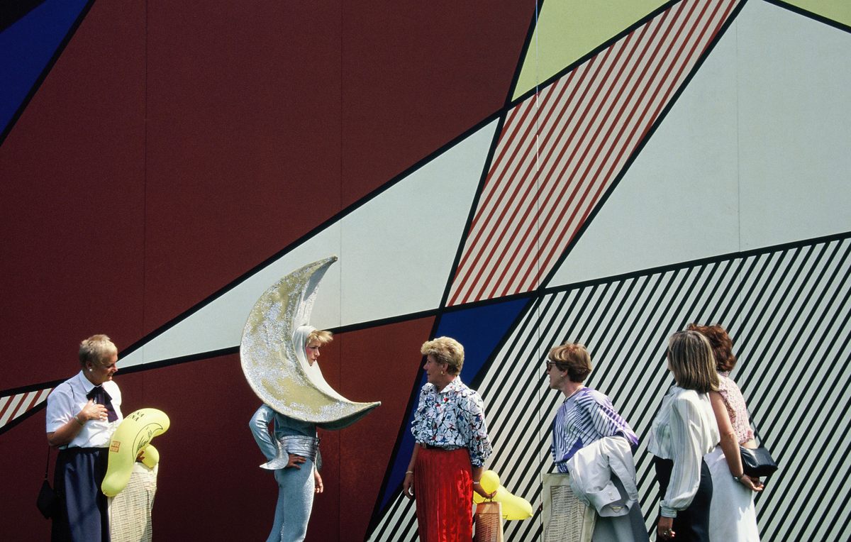 A performer dressed as the moon interacts with visitors outside the pavilion that American Pop Art icon Roy Lichtenstein covered with his "Perfect/Imperfect Paintings."
