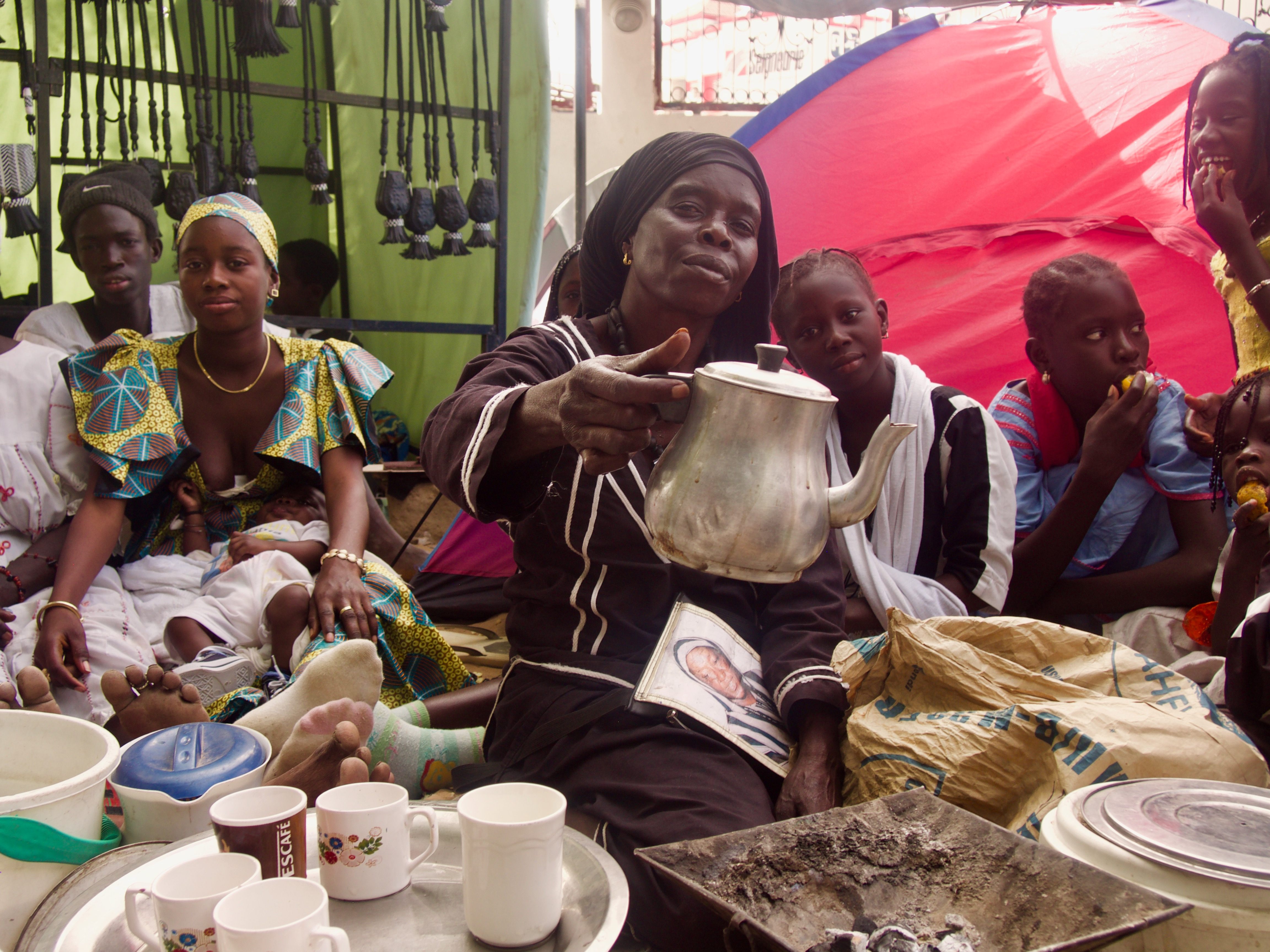 At the marabout's compound, a woman prepares café touba.