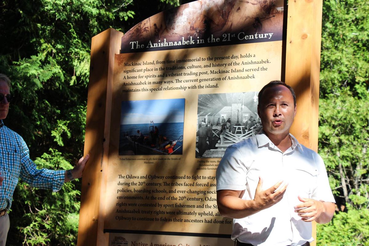 Eric Hemenway, speaking in front of one of the interpretive stations along the Native American history trail around Mackinac Island.