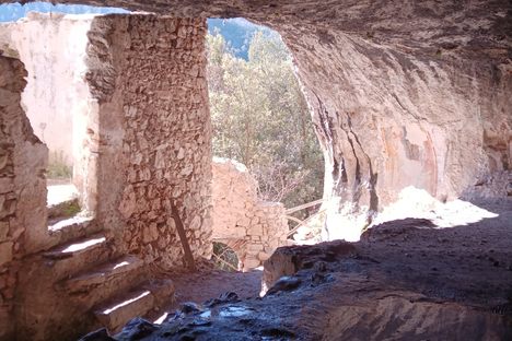 The hermit's house seen from inside the cave with the well on the lower left