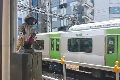 Peeing boy waits for the Yamanote line in his rainy season wear.