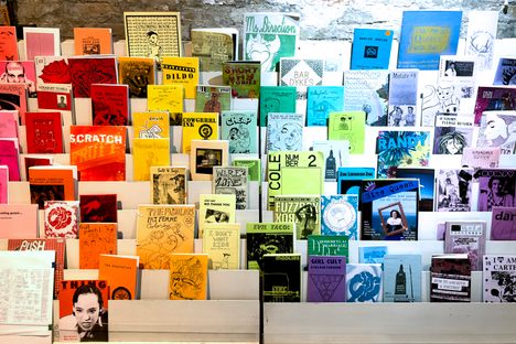 A rainbow display at the Queer Zine Archive Project, curated by QZAP interns Cole Lehto, Clementine Penner, and Kit Gordon in the summer of 2023.