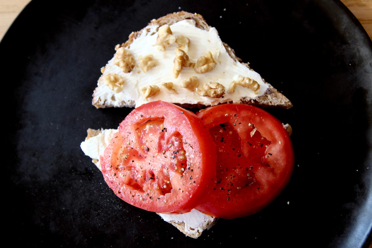 A tomato sandwich with walnuts and Neufchatel.