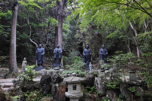 Small statues of Buddha line the path to the top of the mountain.