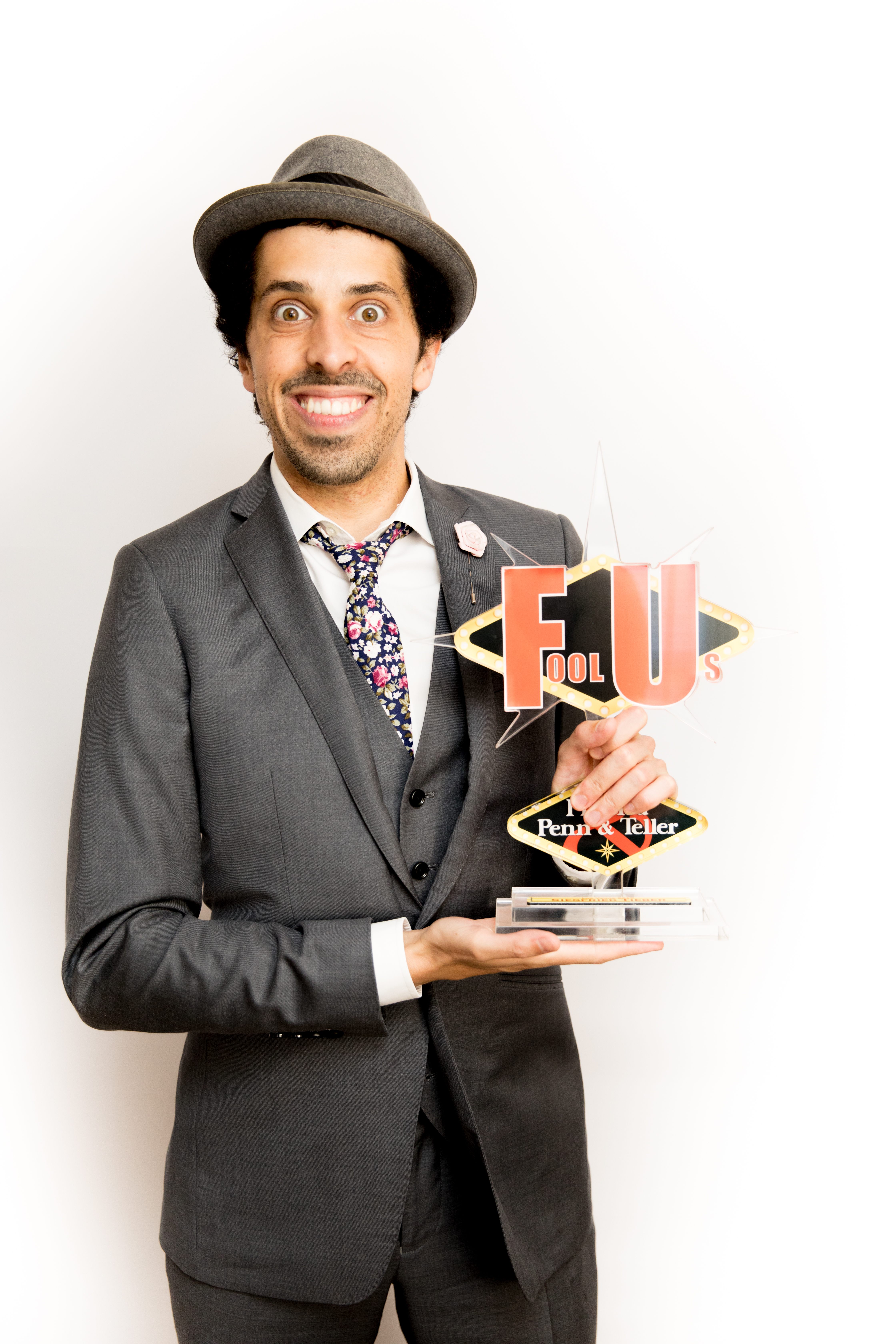 Tieber holds his trophy from his appearance on the magic show <em>Penn & Teller: Fool Us</em>.