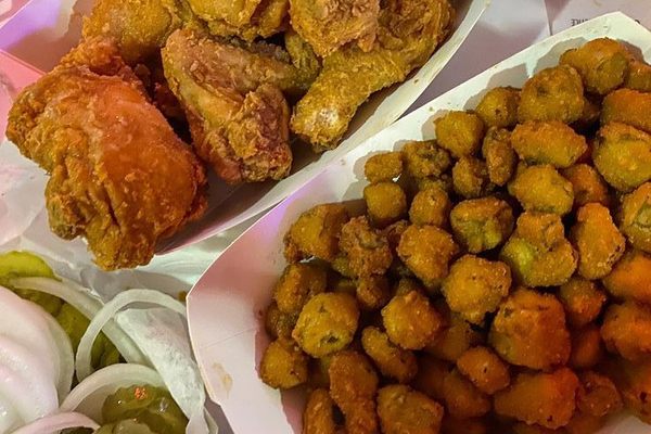 The famous fried chicken, with a side of fried okra, pickles, and onions.