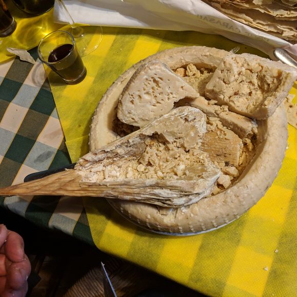 The teardrop-shaped piece resting inside the large wheel is the Callu de Cabrettu. The larger wheel is casu marzu, which is also worth checking out.