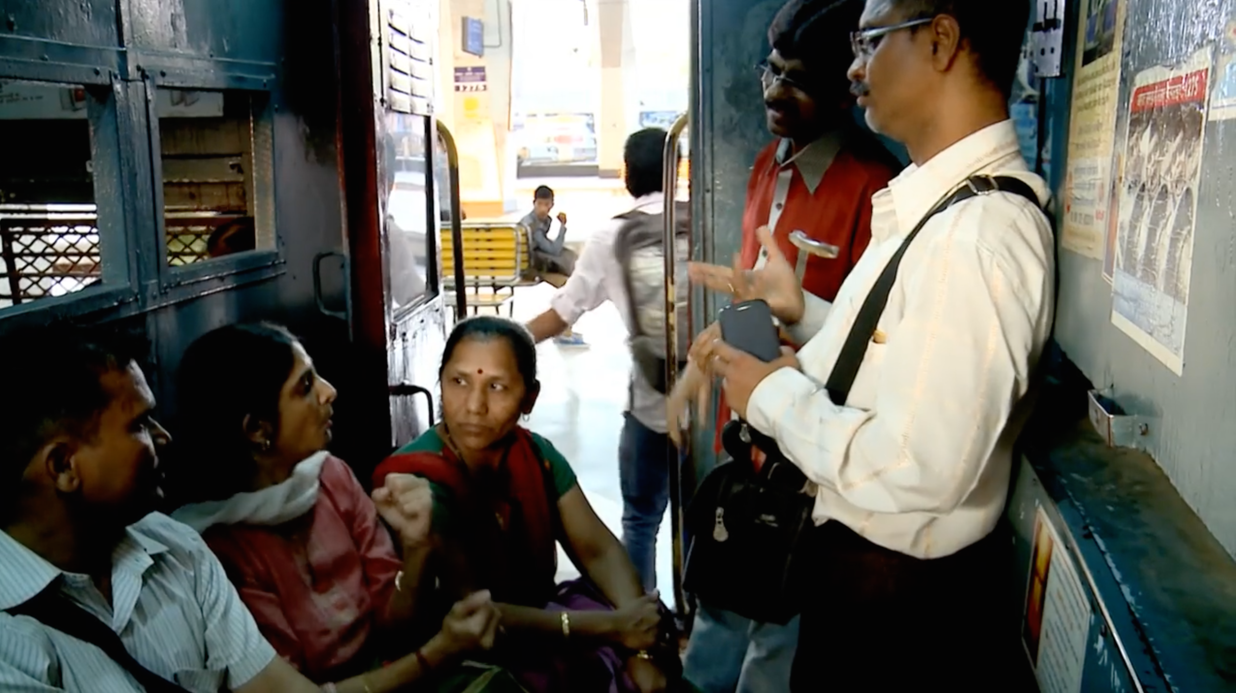 Deaf commuters converse in a Mumbai railway car.