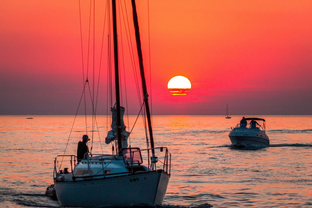 Boats on a tranquil Lake Michigan at sunset—conditions on the lake are often far more challenging, as many a Looper has discovered.