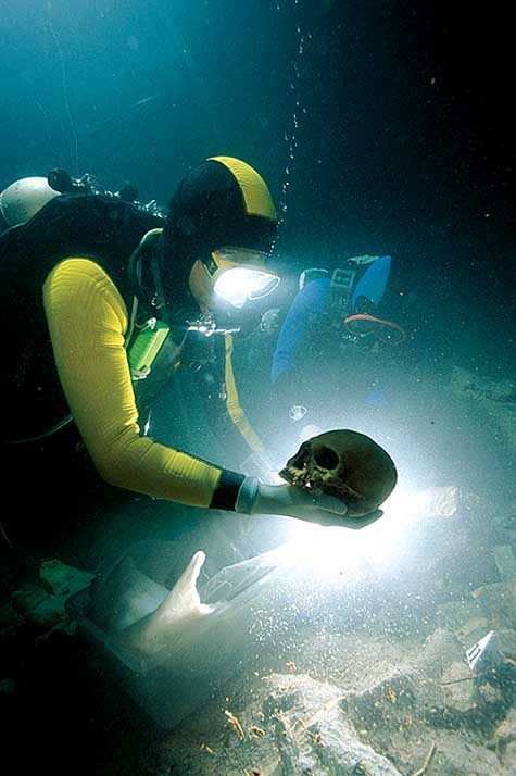 Octavio Del Río recovering the skull of an ancient ancestor from a sacred cenote inside a cave near Tulum, Mexico.