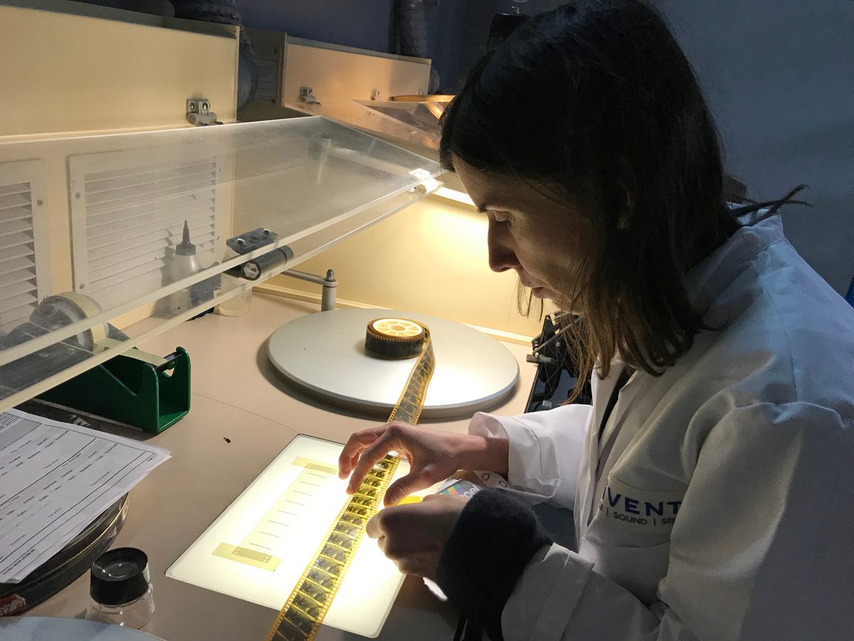 Lead conservator Céline Ruivo examines a strip of nitrate film.