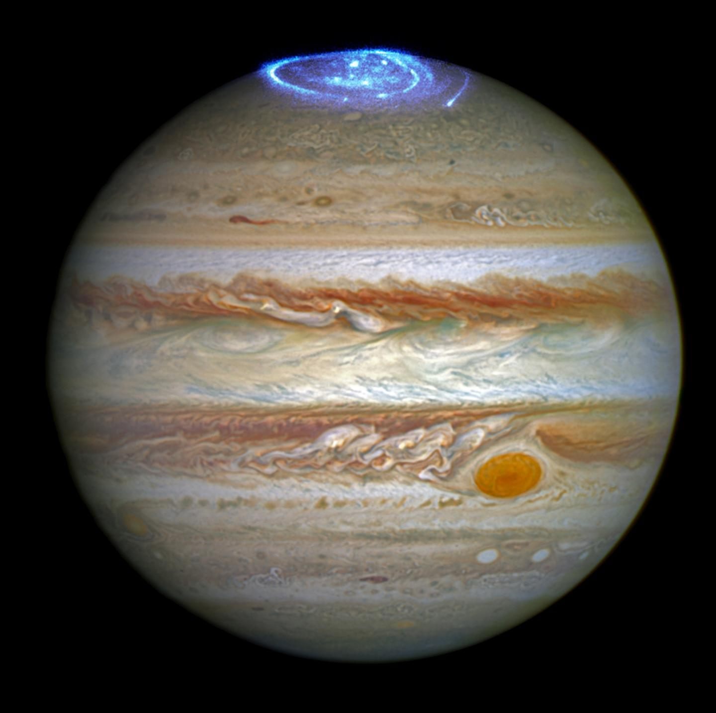 An optical image of Jupiter, taken by Hubble in 2014, is overlaid with an ultraviolet image taken by Juno in 2016.