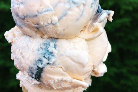 A double scoop of orange-flavored tiger tail ice cream striped with black licorice ribbons.