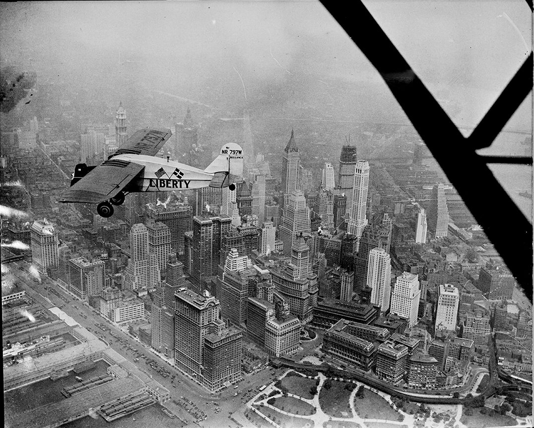 “Liberty bellanca monoplane in the air (over N.Y.C.) on first leg of its flight to Denmark. From Hasbrouck Heights, N.J. with Otto Hillig of Liberty, N.Y., flying photographer and Capt. Hoérüs, the pilot”