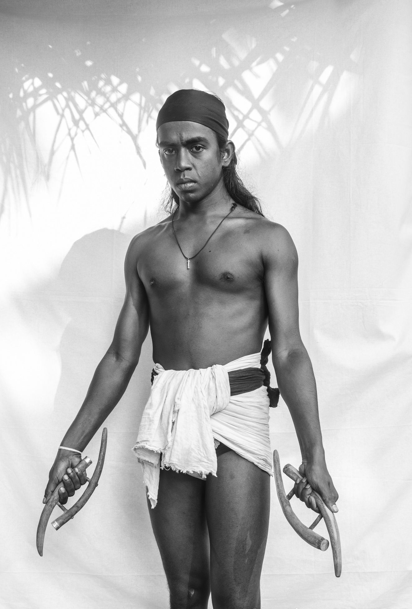 A fighter holds a traditional weapon known as <em>an-kirinnya</em>, a melee weapon made of deer antlers.