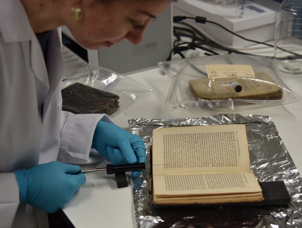 Cecilia sampling the volatile organic compounds (VOCs) of a historic book using solid phase microextraction (SPME) at the Heritage Science Lab in UCL.